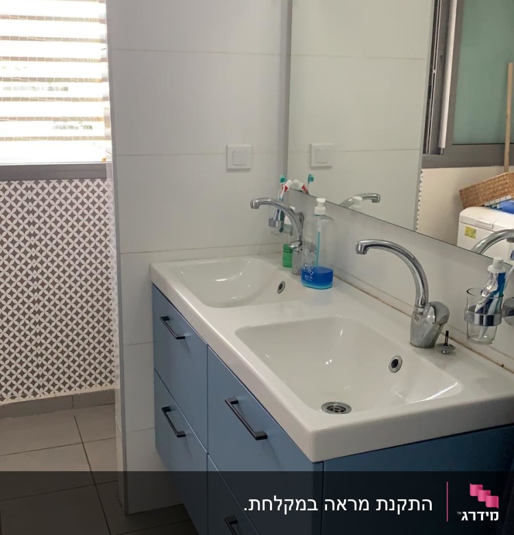 שני כיורים עם ברזים על ארון אמבטיה כחול